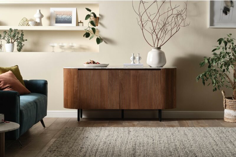 Modern Stowe fluted mango wood sideboard with a solid marble top in a neutral living room with a blue velvet sofa.