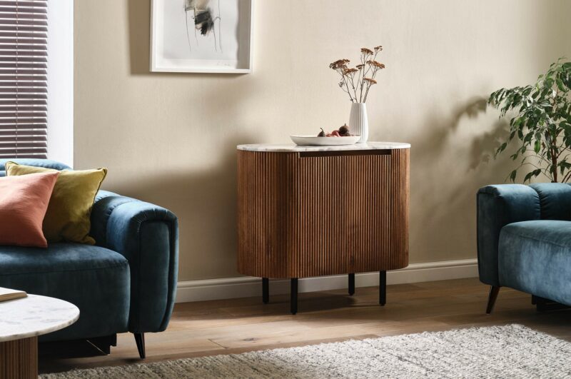 Oak Furnitureland fluted mango wood sideboard with a solid marble top in a modern living room.