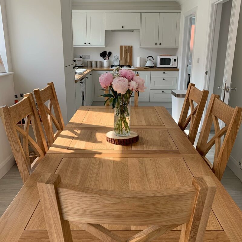 Dorset dining table and matching chairs in a modern kitchen, with peonies displayed on the table.