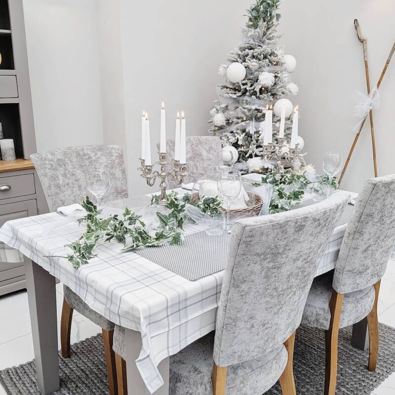 Elegant white Christmas tablescape on the Oak Furnitureland St. Ives table with upholstered dining chairs.