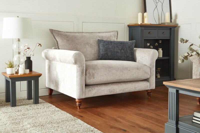 Oak Furnitureland neutral Bassett loveseat with contrasting grey scatter cushion in a living room with inky blue painted and rustic oak furniture.