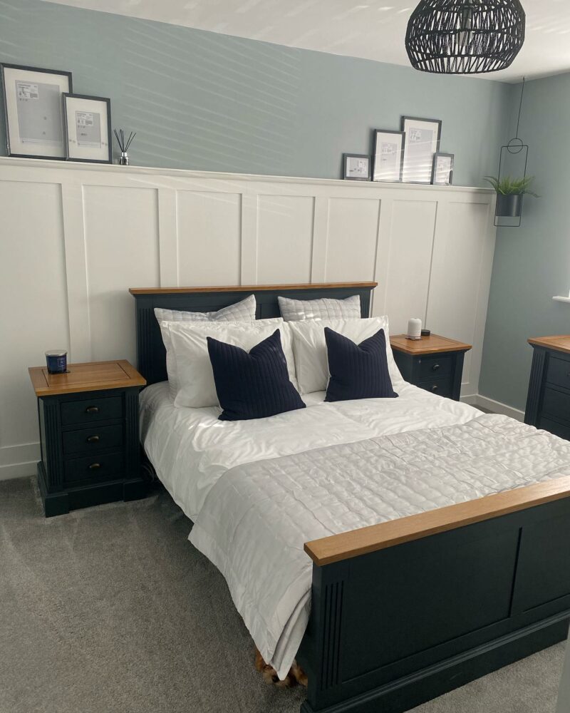 Inky blue Oak Furnitureland Highgate bed and matching bedside table in a white and duck egg blue bedroom.