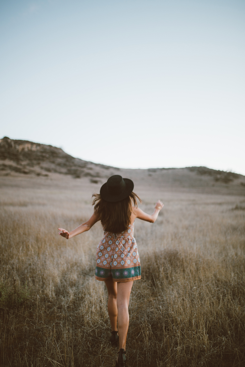 Woman walking in field of wheat