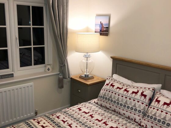 St. Ives grey painted bed styled with festive chalet-style bedding.