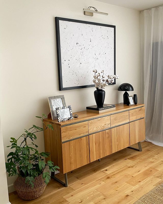 Oak sideboard with metal details in dining room, styled with frames and other decorative accessories.