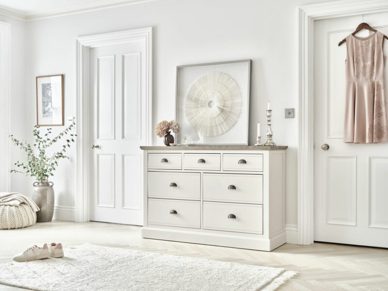 Brompton off-white chest of drawer with an ash top, in a white bedroom with elegant accessories.