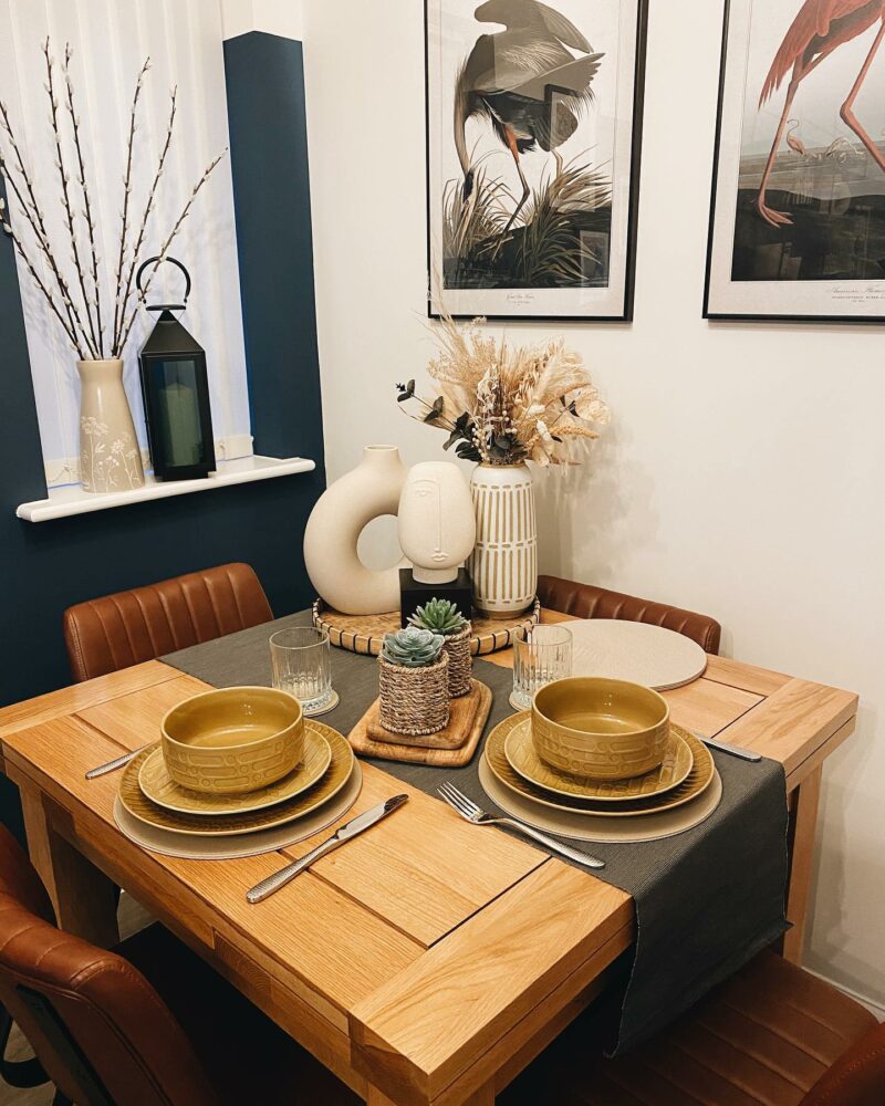 Dorset square natural oak dining table set with retro mustard tableware and statement artwork.