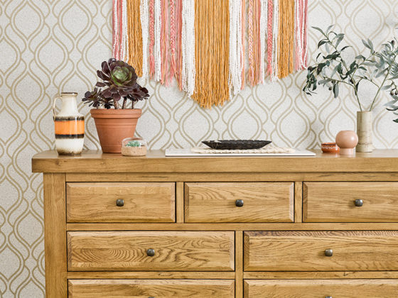 light oak chest of drawers against geometric wallpaper