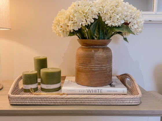 Oak Furnitureland Brompton small sideboard styled with white flowers and olive green candles.