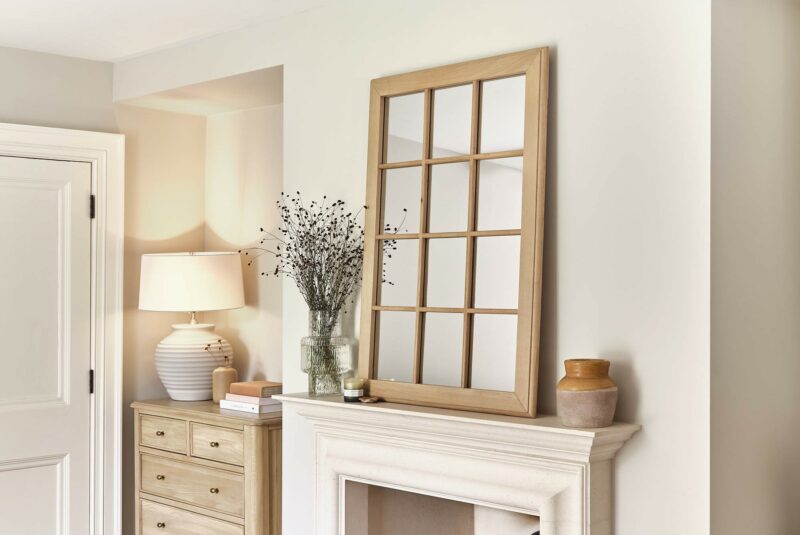 Newton window-pane style light oak mirror displayed above a fireplace and next to the Newton chest of drawers.