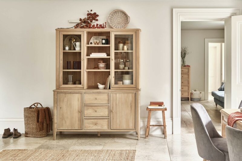 Neutral dining space featuring the Newton large natural oak dresser filled with decorative objects and crockery.