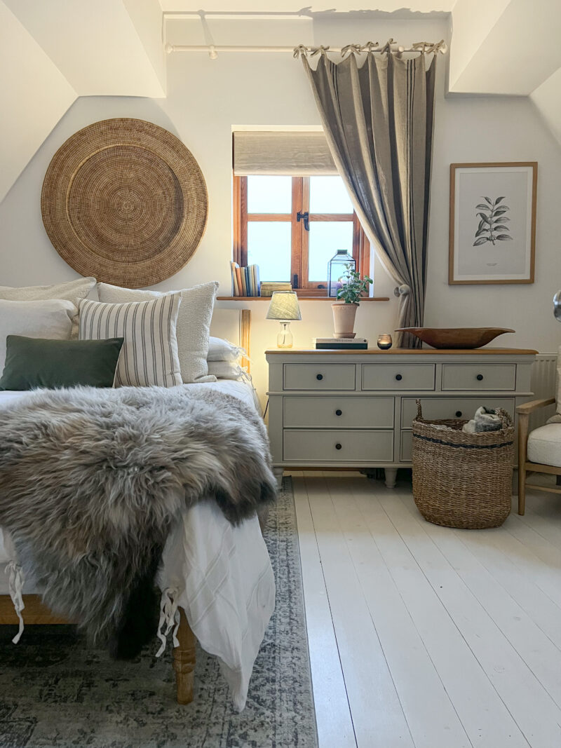 Oak Furnitureland almond grey painted grey Shay 7-drawer chest in a modern boho-styled bedroom.