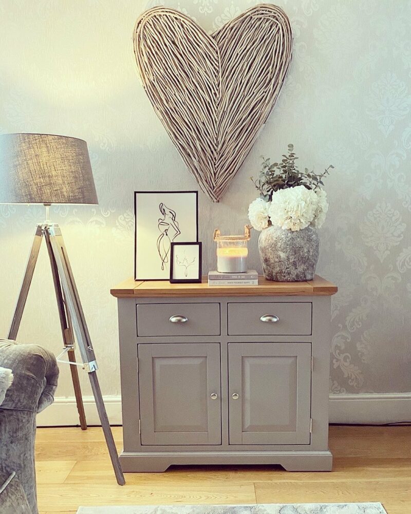 Oak Furnitureland pale grey painted St. Ives sideboard with oak top, styled with neutral accessories and flowers.