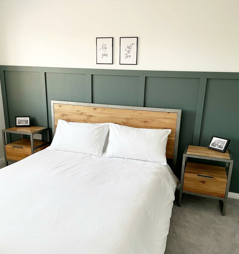 Industrial style bed and bedside table against a panelled wall