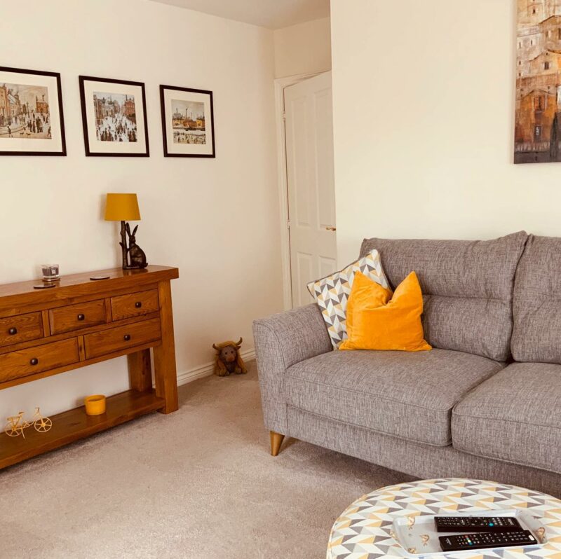 Jensen Grey Sofa with yellow cushions in a living room