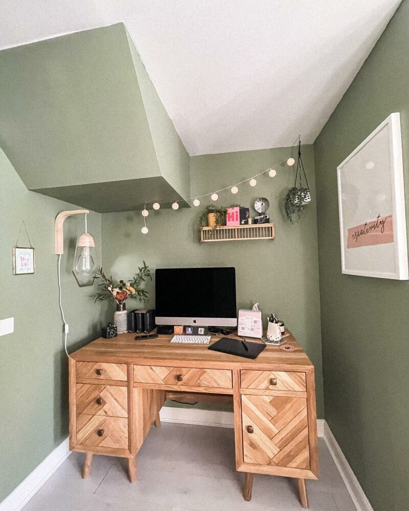 Oak Furnitureland Parquet desk in a muted green home office with string lights and white wall art.