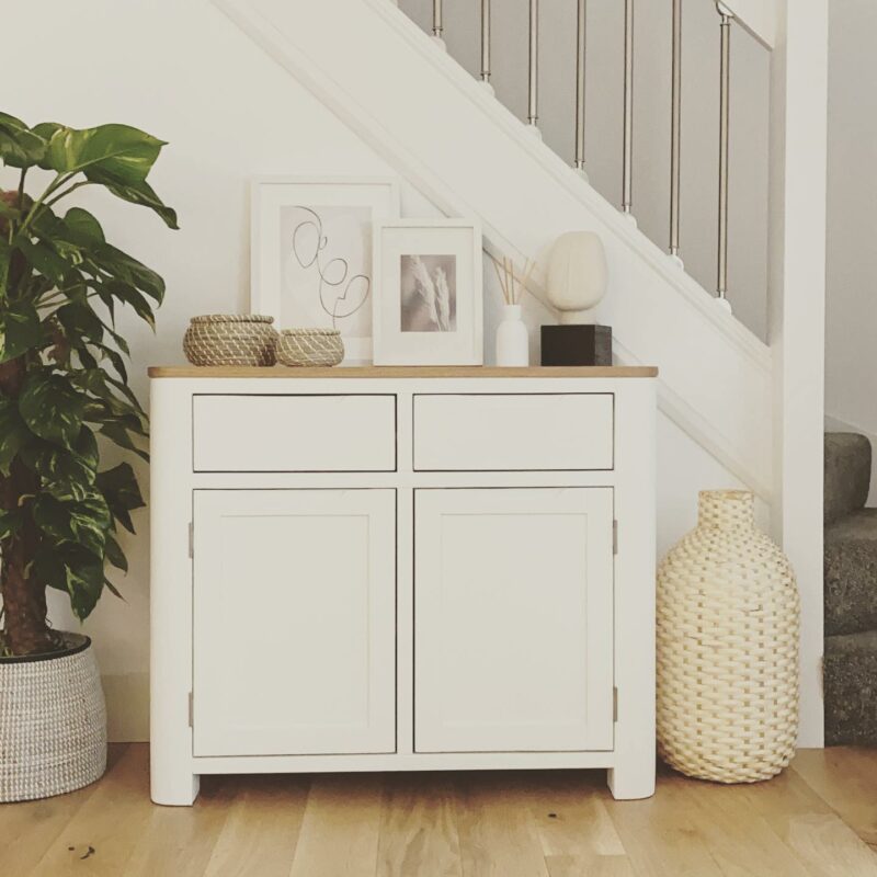 Hove off-white painted small sideboard styled in a hallway with greenery and decorative accessories.