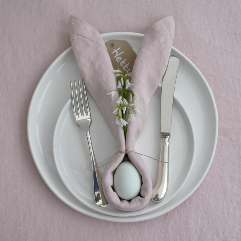 DIY Easter table decor with a bunny place setting made from a pale pink napkin, twine & an egg.