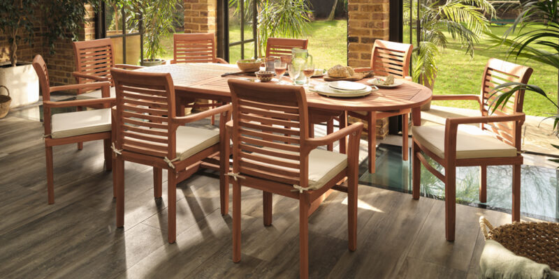 Oak Furnitureland Cayman 8-seater extendable teak outdoor dining table set for a summer lunch.