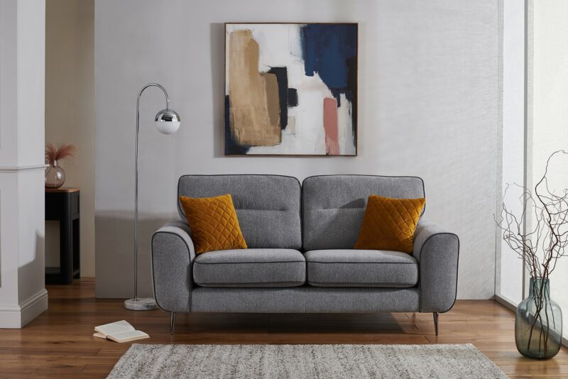 Grey contemporary Fiesta sofa with mustard yellow scatter cushions, statement art and a floor lamp.