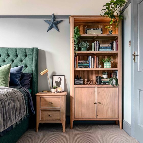 A bed, a bookcase and bedside table-bedroom furniture-upholstered double bed-wooden bedside table with drawers-wooden bookcase-green upholstered bed-grey wall colour