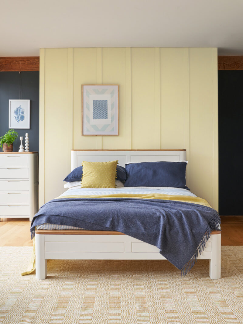 Oak Furnitureland Hove off-white painted hardwood and natural oak bedroom furniture with contrasting walls painted in neutral warm yellow/beige tone.