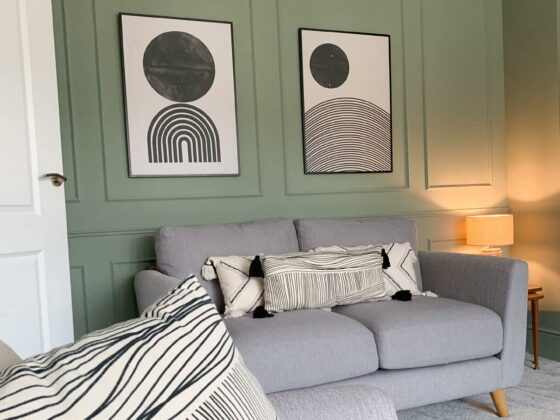 Mint green panelled living room with grey Evie sofa and monochrome art on the wall.