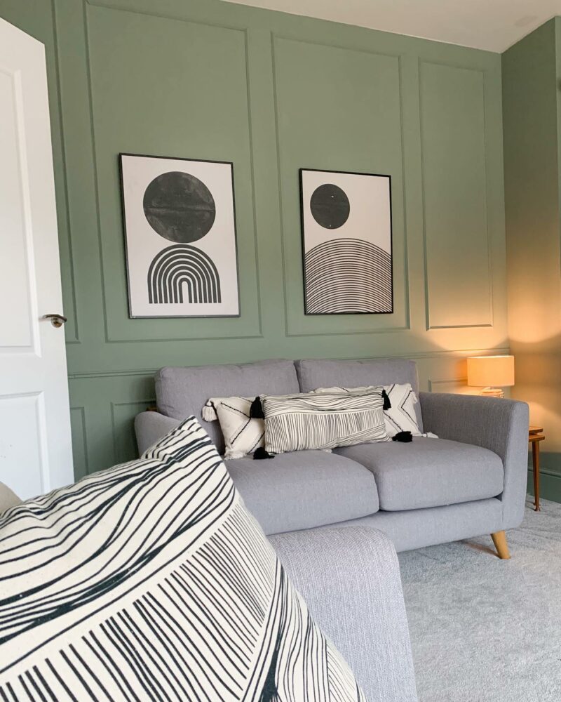 Mint green panelled living room with grey Evie sofa and monochrome art on the wall.