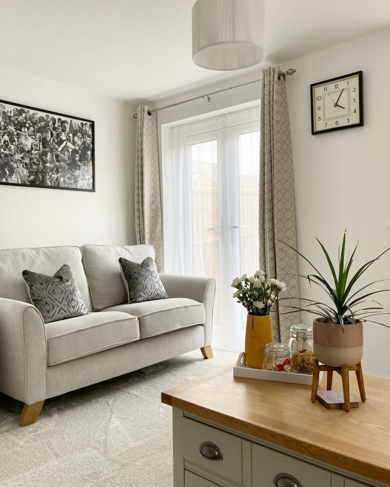 Elegant Jasmine grey sofa in a neutral living room with art, plants and oak and painted furniture. 