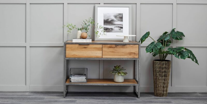 Brooklyn natural oak and metal console table styled with artwork and plants.