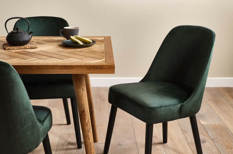 Oak Furnitureland Parquet dining table with green velvet Bette dining chairs.