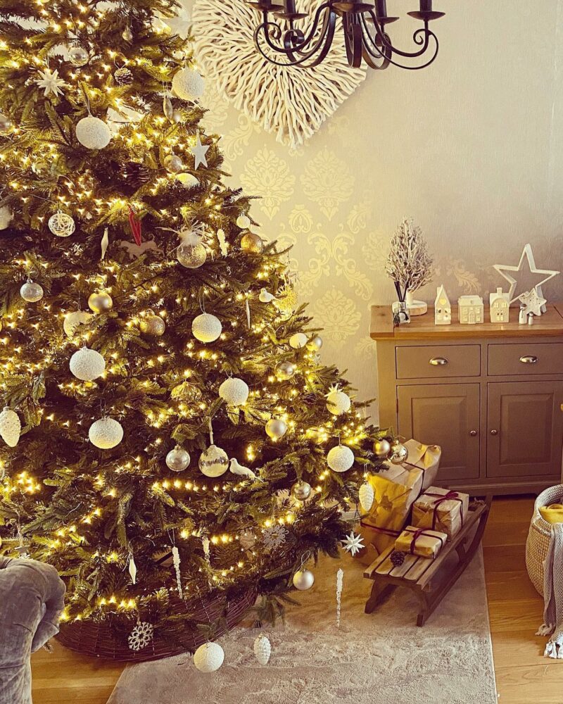 Painted grey small sideboard in a living room next to a decorated Christmas tree.