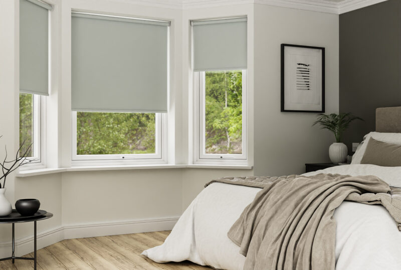 Neutral bedroom scheme with grey blinds in bay window.