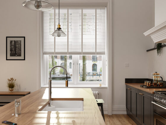 Light-filled kitchen with white walls, wooden blinds and neutral decor.