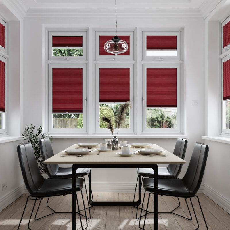 Magenta-coloured pleated black out blinds in dining room.