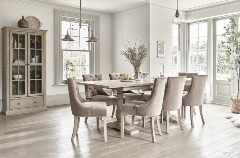 Oak Furnitureland Burleigh extendable dining table in a light-filled room with a matching glazed cabinet.