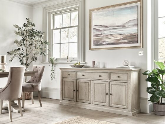 Oak Furnitureland weathered oak Burleigh furniture, including large sideboard and dining table, with art and houseplants.
