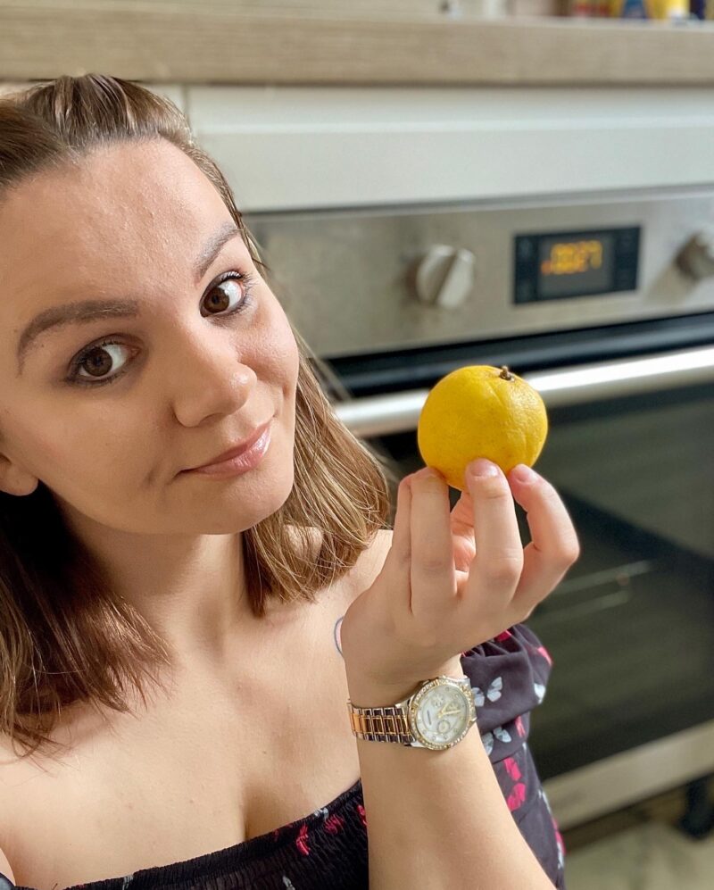 Dominika, also known as Washy Wash, is a cleanfluencer, pictured here with a lemon next to an oven.