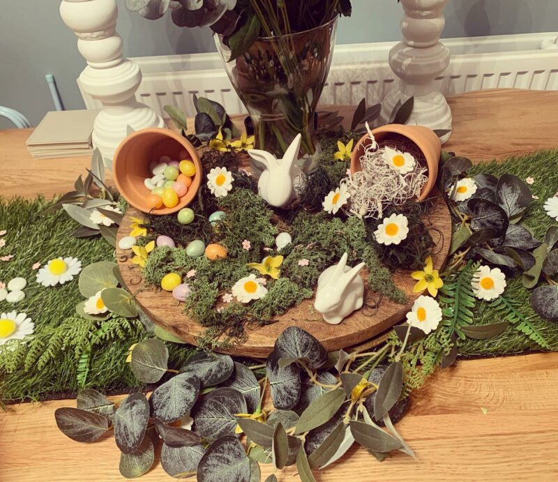 Easter themed table centrepiece with foliage, bunny figures and plant pots on the Brooklyn dining table