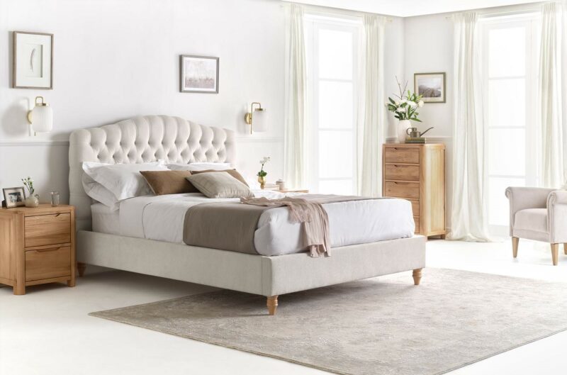 Chesterfield-inspired upholstered bed in netural bedroom with natural oak bedroom furniture.