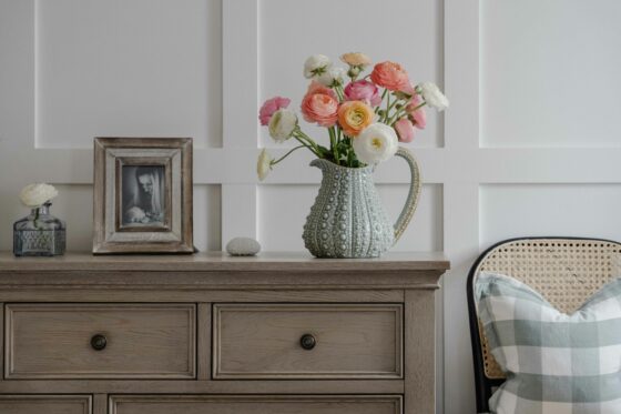 Burleigh weathered oak chest with a bright bunch of flowers in a vintage jug and other decorative accessories.