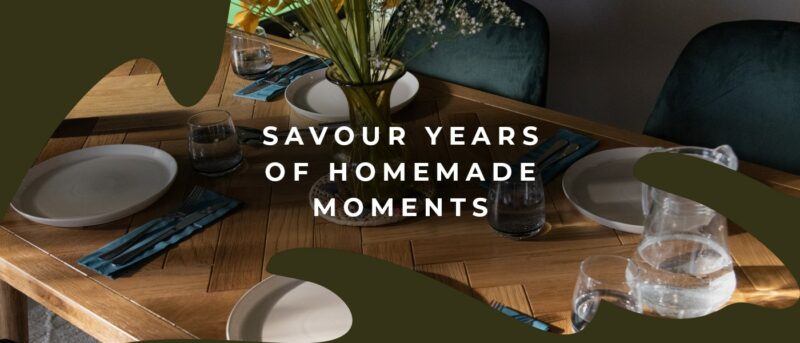 Close up of the Oak Furnitureland Parquet table set for a meal with crockery and a vase of flowers.