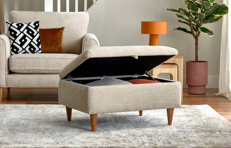 An armchair and footstool-living room furniture-a beige armchair with wooden legs and storage footstool