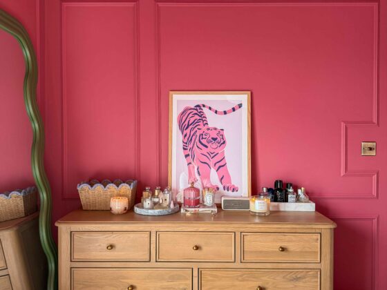 A chest of drawers-bedroom furniture-bright pink walls with panelling-oak chest of drawers-green wiggle floor standing mirror-parquet flooring-tiger wall art-scallop edge storage basket-marble trays-perfume-candles-skincare
