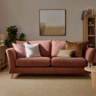 A sofa, coffee table, display cabinet, and console table-living room furniture-terracotta coloured sofa-wooden console table-neutral walls-sisal carpet-cream vase with dried flowers-potted house plant-framed photo-glass lamp-neutral abstract wall art-draped sheer curtain-wooden and glass display cabinet-round wooden coffee table