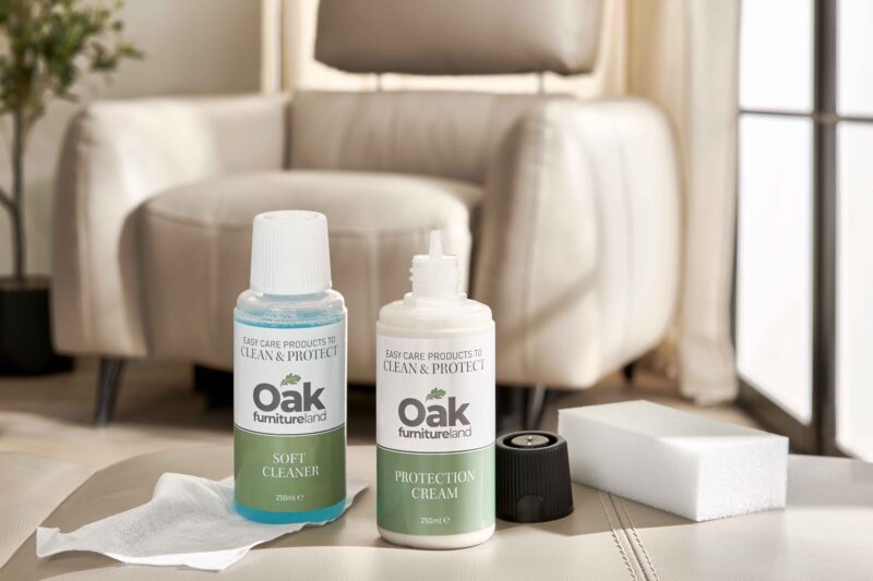 Bottles of leather cleaner-living room-soft leather cleaner in green and white bottle-leather protection cream in green and white bottle-cream leather footstool-cream leather armchair-crittall windows-potted houseplant